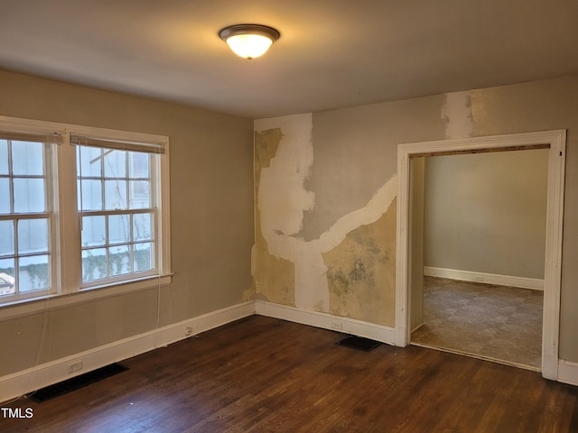 unfurnished room featuring plenty of natural light and dark hardwood / wood-style floors