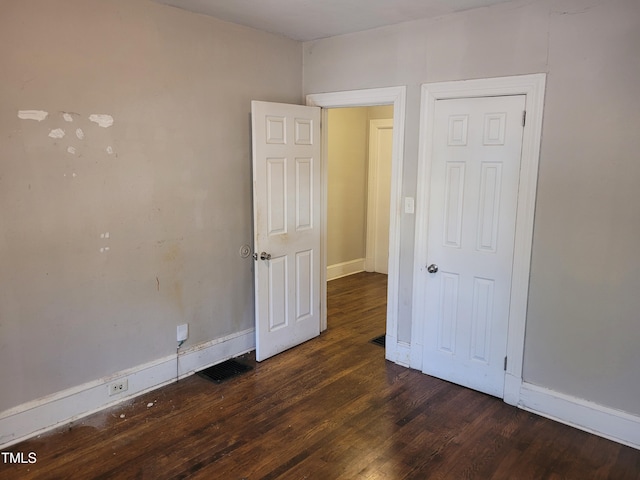 unfurnished bedroom with dark hardwood / wood-style floors