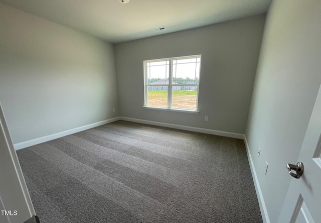 unfurnished room with carpet, visible vents, and baseboards