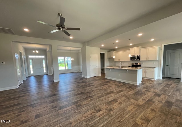 kitchen with stainless steel appliances, dark wood-type flooring, a sink, white cabinets, and open floor plan