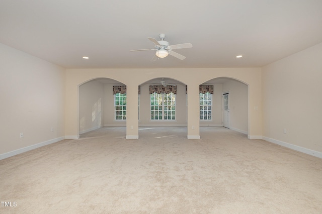 empty room with ceiling fan and light carpet