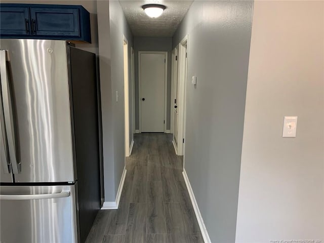 hallway with dark hardwood / wood-style floors and a textured ceiling