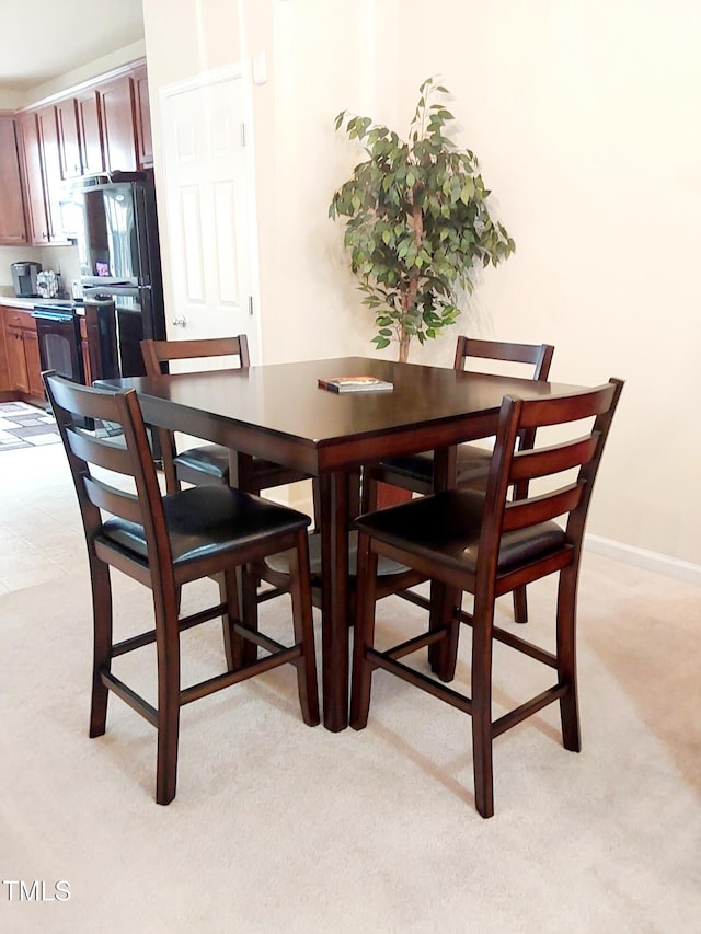 dining space featuring light carpet