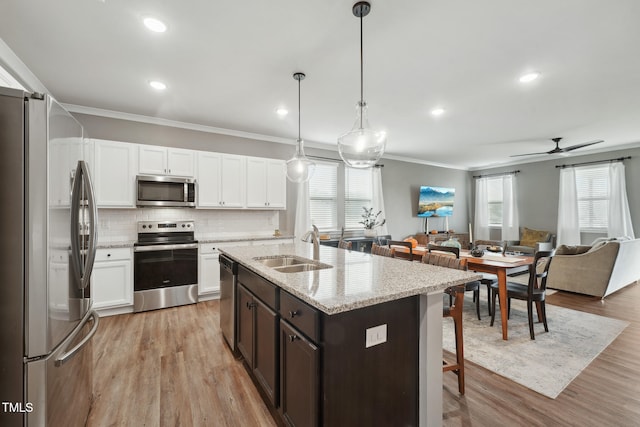 kitchen with decorative light fixtures, sink, stainless steel appliances, and plenty of natural light