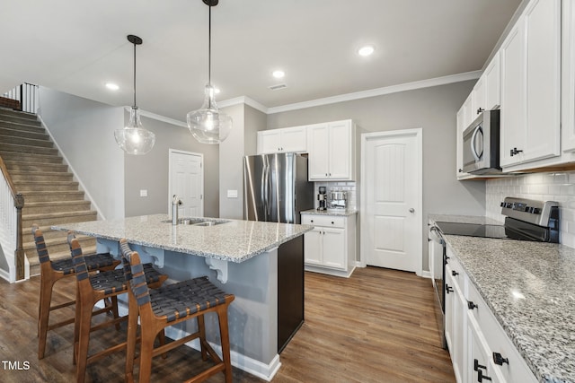 kitchen with tasteful backsplash, white cabinetry, sink, and stainless steel appliances