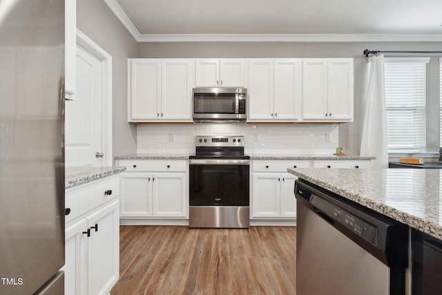 kitchen featuring light hardwood / wood-style flooring, white cabinetry, stainless steel appliances, and light stone counters