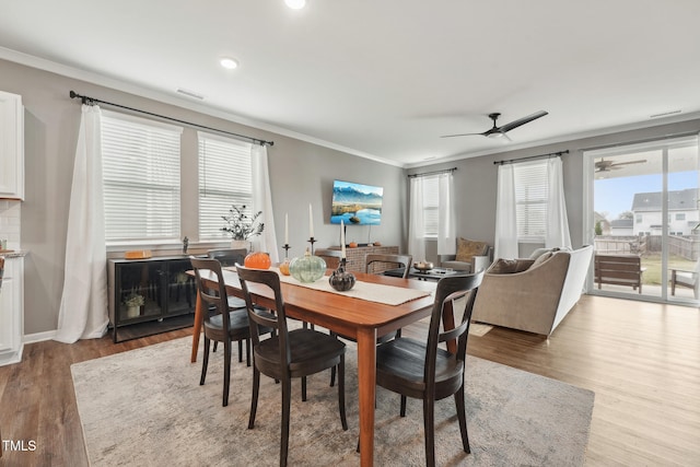 dining room with crown molding, light hardwood / wood-style flooring, and ceiling fan