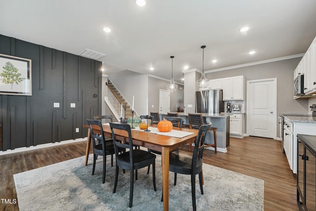 dining space featuring dark hardwood / wood-style floors and ornamental molding