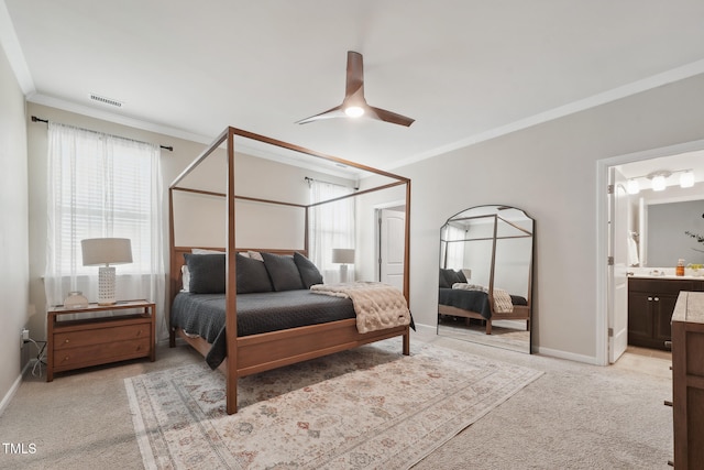 carpeted bedroom featuring crown molding, ceiling fan, multiple windows, and ensuite bathroom