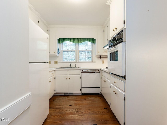 kitchen with white cabinets, dark hardwood / wood-style flooring, sink, and white appliances