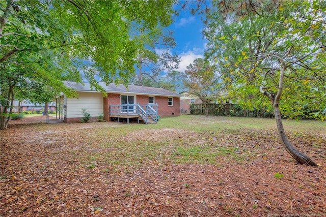 rear view of house featuring a deck and a lawn