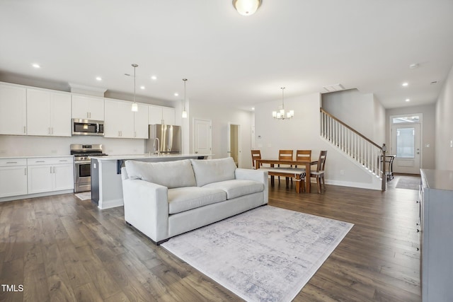 living room with a chandelier and dark hardwood / wood-style floors