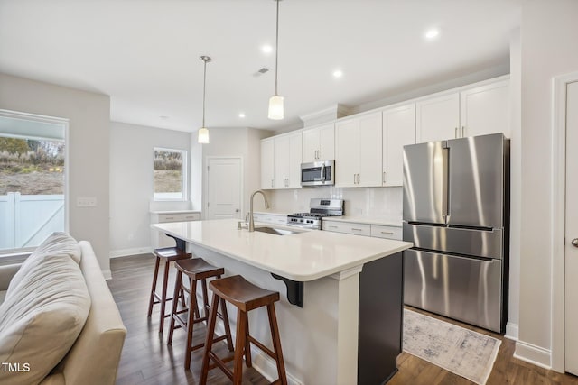 kitchen featuring white cabinets, sink, an island with sink, and appliances with stainless steel finishes