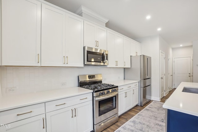 kitchen featuring tasteful backsplash, white cabinetry, dark hardwood / wood-style floors, and appliances with stainless steel finishes