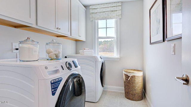 laundry area with cabinets, washing machine and clothes dryer, and light tile patterned flooring