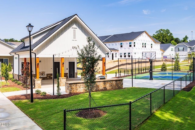 view of sport court featuring tennis court and a yard