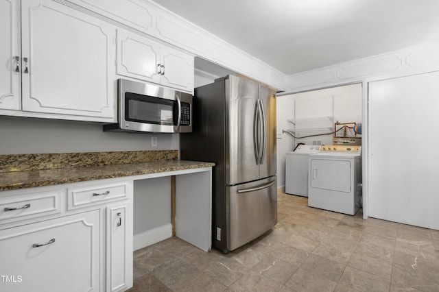 kitchen with white cabinets, separate washer and dryer, appliances with stainless steel finishes, and dark stone countertops