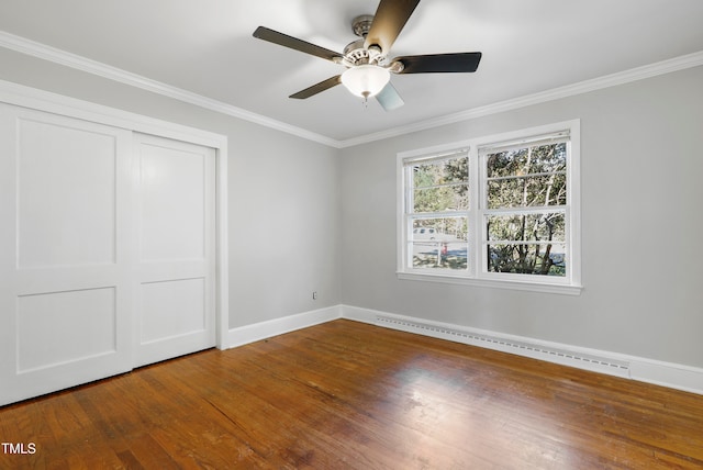 unfurnished bedroom featuring hardwood / wood-style flooring, ceiling fan, a baseboard heating unit, and ornamental molding