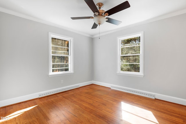 empty room featuring baseboard heating, hardwood / wood-style floors, ceiling fan, and crown molding