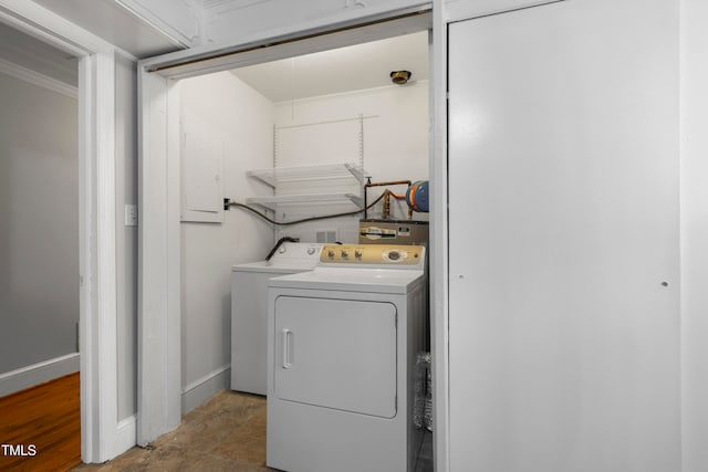 laundry area with hardwood / wood-style floors, crown molding, and washer and dryer