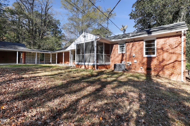 rear view of property with a lawn and a sunroom