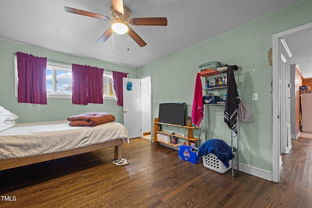 bedroom with dark hardwood / wood-style flooring and ceiling fan