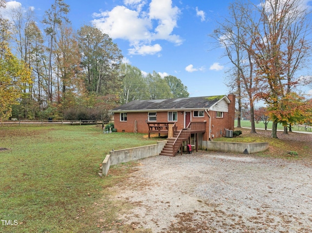 view of front of property with central air condition unit, a deck, and a front lawn