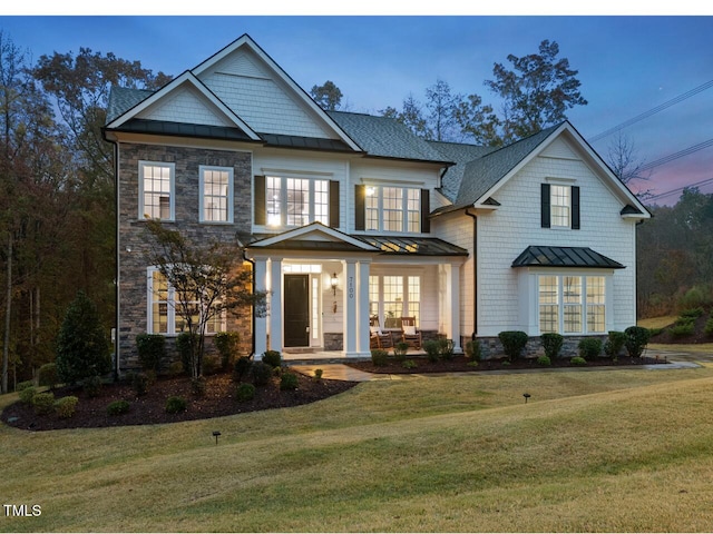 craftsman inspired home with covered porch and a yard