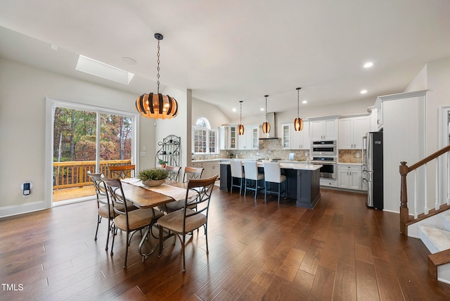 dining area featuring a skylight, a chandelier, and dark hardwood / wood-style floors