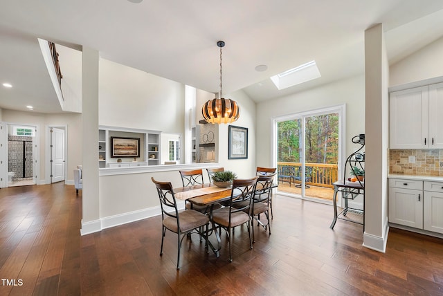 dining space featuring dark hardwood / wood-style floors, lofted ceiling with skylight, and a notable chandelier