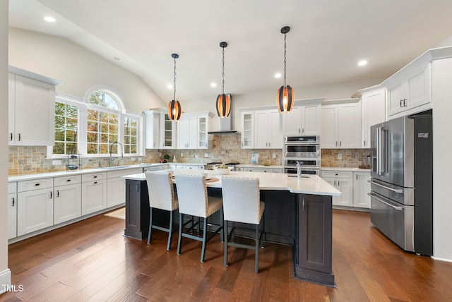 kitchen with white cabinets, a kitchen island, dark wood-type flooring, and appliances with stainless steel finishes