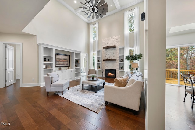 living room featuring a towering ceiling, a healthy amount of sunlight, and hardwood / wood-style flooring