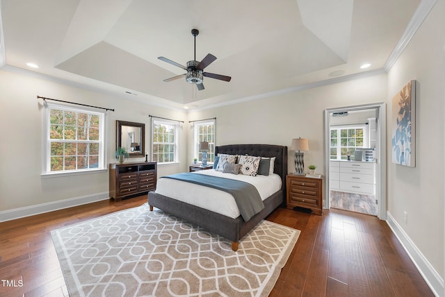 bedroom with a tray ceiling, crown molding, ceiling fan, and dark wood-type flooring