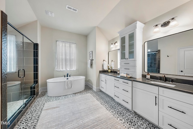 bathroom with tile patterned floors, vanity, separate shower and tub, and lofted ceiling