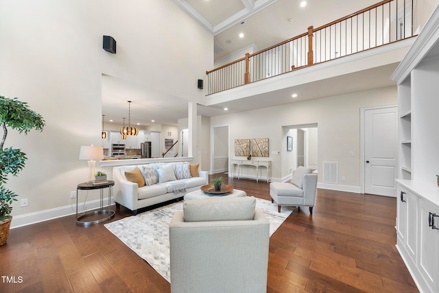 living room featuring dark wood-type flooring, a high ceiling, and an inviting chandelier