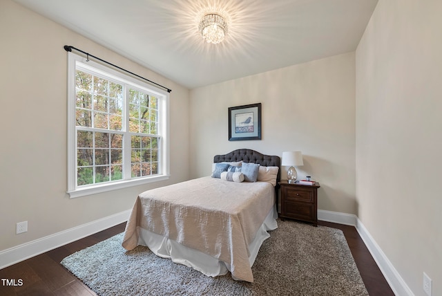 bedroom featuring dark wood-type flooring and an inviting chandelier