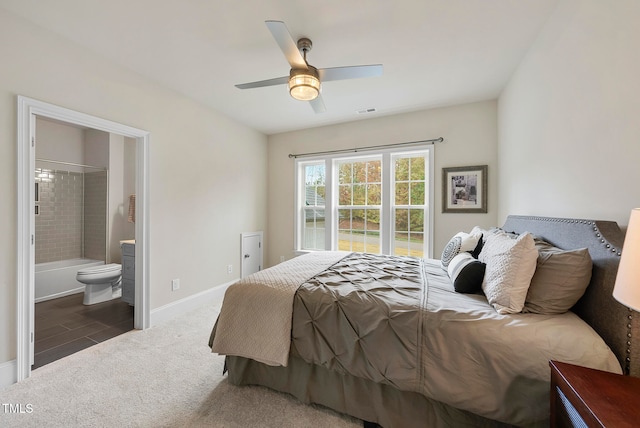 bedroom with dark colored carpet, ensuite bathroom, and ceiling fan