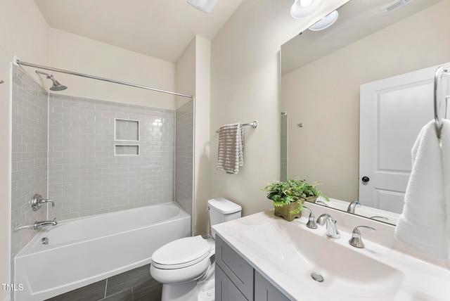 full bathroom featuring tile patterned floors, toilet, vanity, and tiled shower / bath