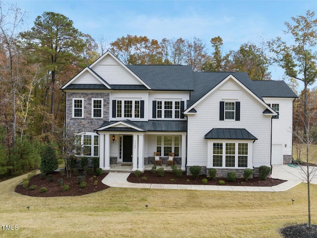 craftsman inspired home with a porch, a front yard, and a garage