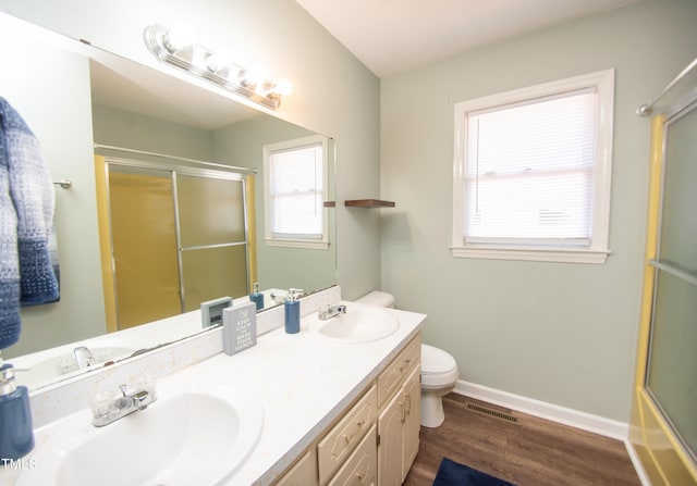 full bathroom featuring hardwood / wood-style floors, vanity, toilet, and shower / bath combination with glass door