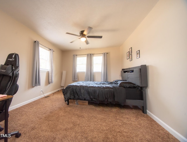 bedroom featuring multiple windows, ceiling fan, and carpet floors