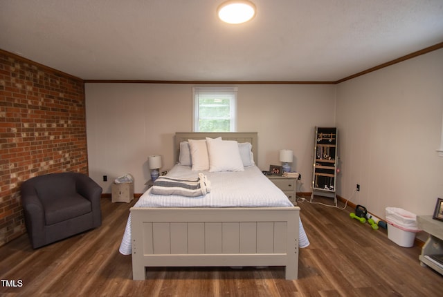 bedroom with crown molding, brick wall, and dark hardwood / wood-style floors