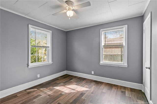 spare room featuring dark hardwood / wood-style flooring, a wealth of natural light, ceiling fan, and crown molding