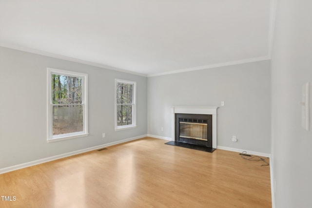 unfurnished living room featuring light hardwood / wood-style floors and crown molding