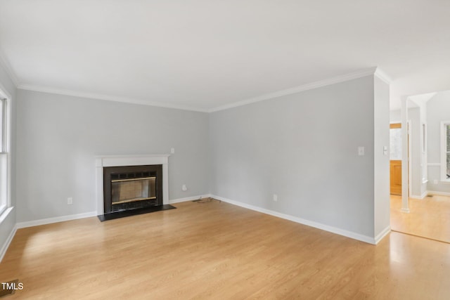 unfurnished living room with light hardwood / wood-style floors, crown molding, and a wealth of natural light