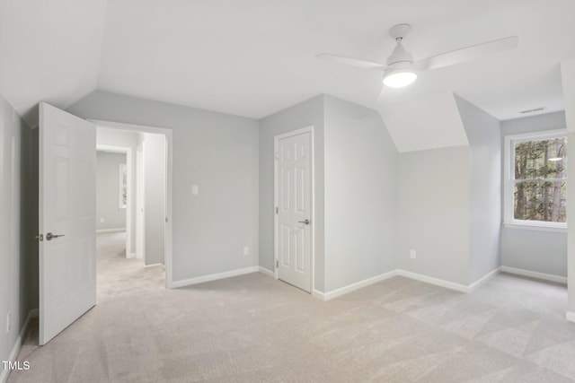 additional living space featuring ceiling fan, light colored carpet, and lofted ceiling