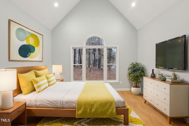 bedroom featuring light hardwood / wood-style floors and high vaulted ceiling