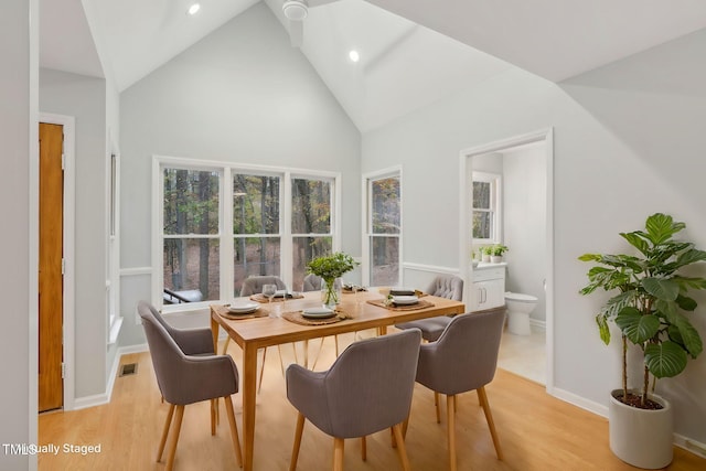 dining area featuring light hardwood / wood-style flooring and high vaulted ceiling