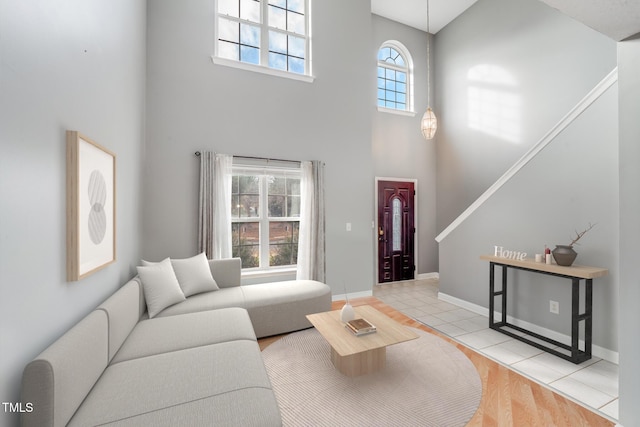 living room with a towering ceiling and light tile patterned flooring