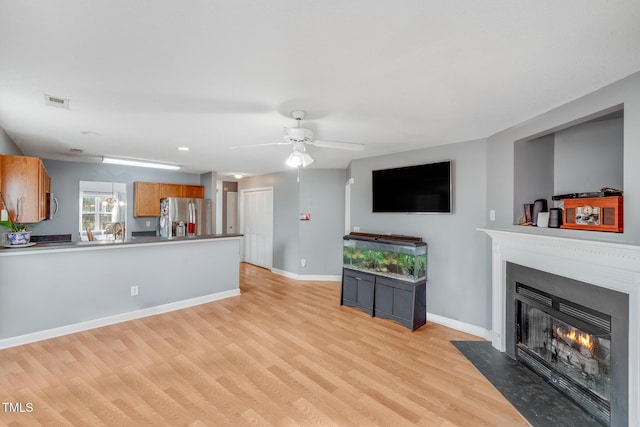 living room with light hardwood / wood-style floors and ceiling fan